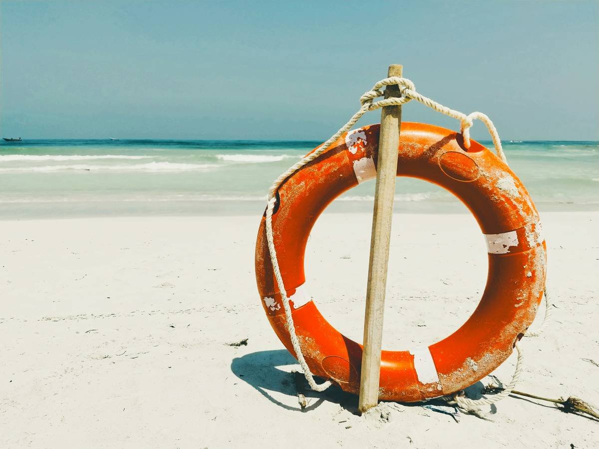 A life preserver on a beach with the ocean in the background