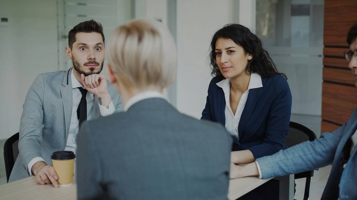 Business team chatting while sitting at the table in modren office indoors during coffee break