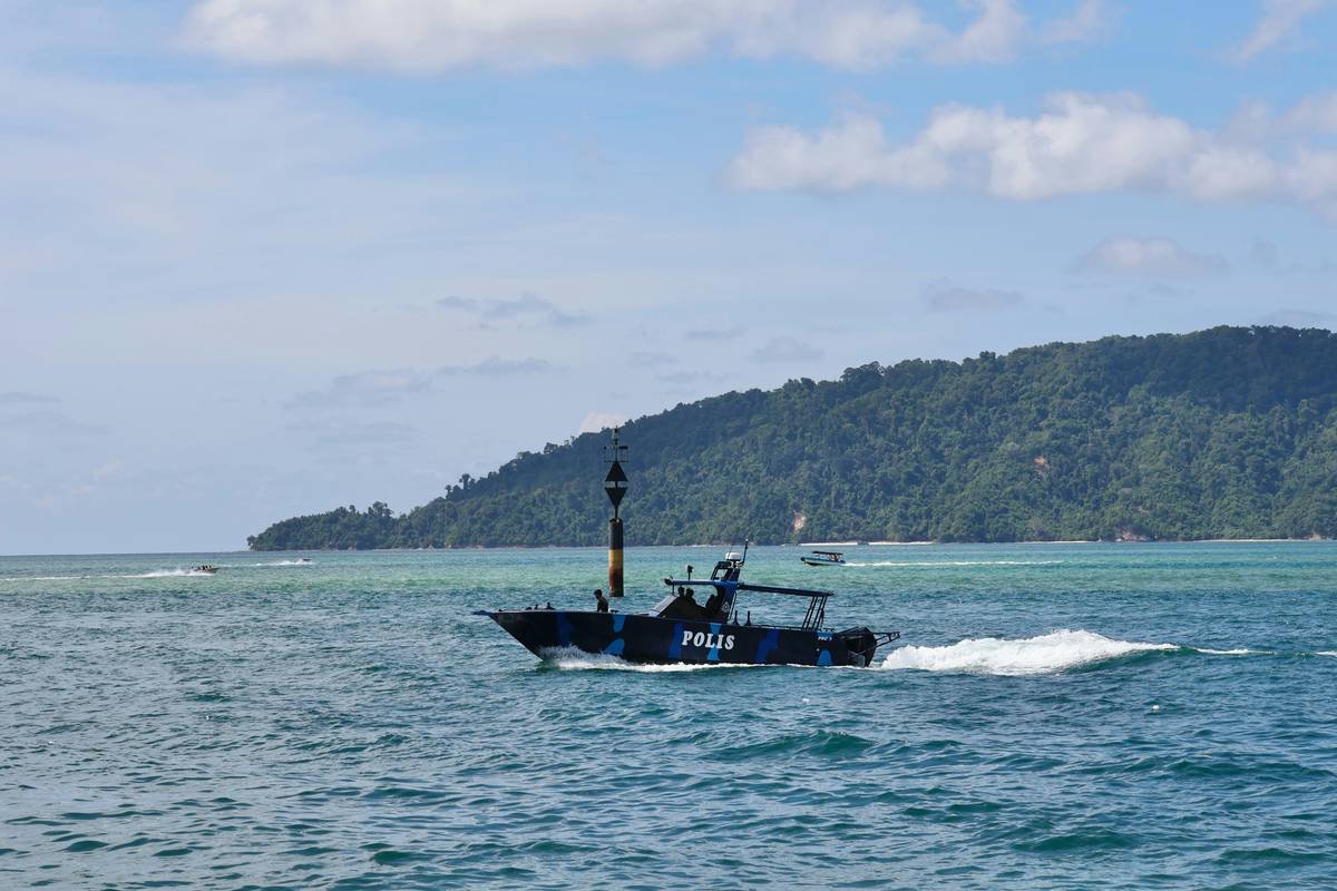 Police boat sailing on the ocean near island