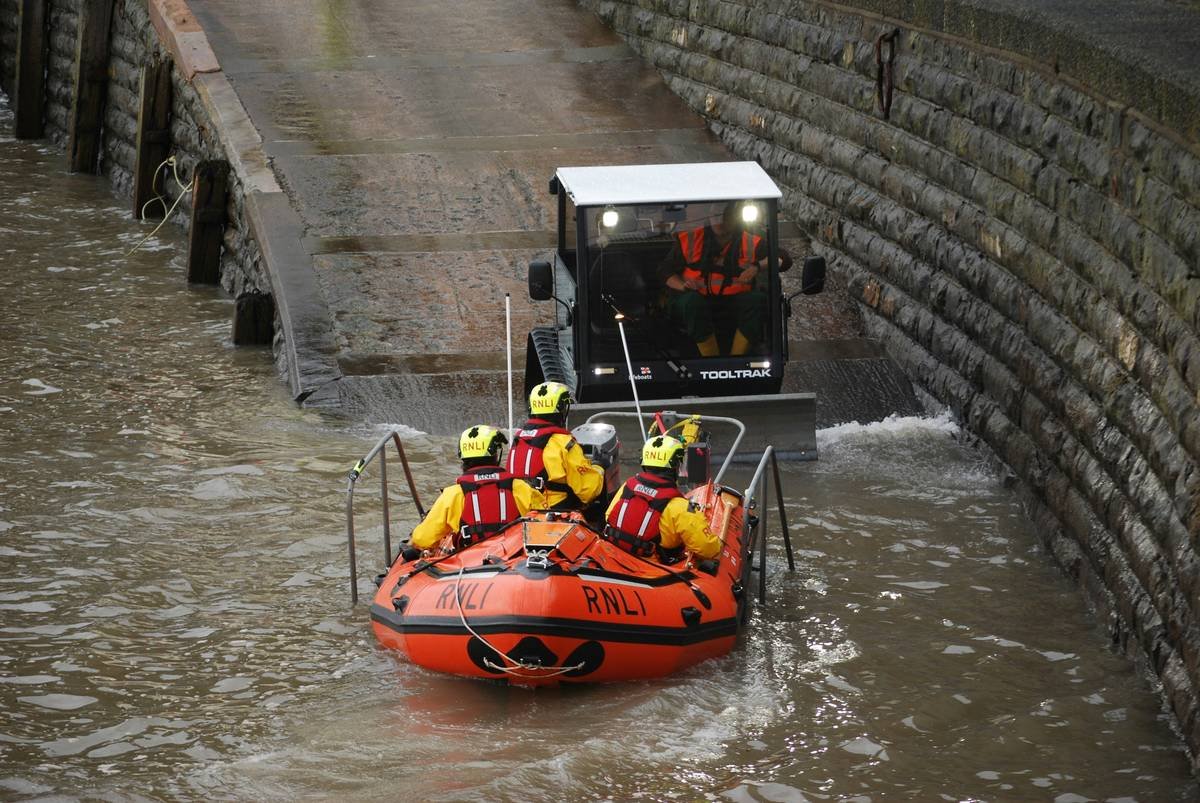 Rescue boat with crew being pulled by tractor